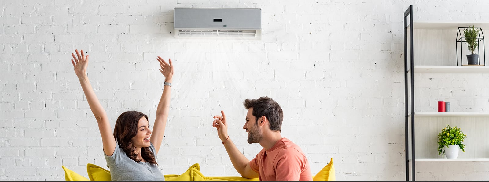 Couple sitting in front of a AC