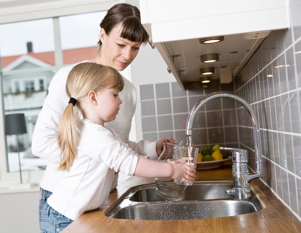 Mom and daugher filling a cup of water