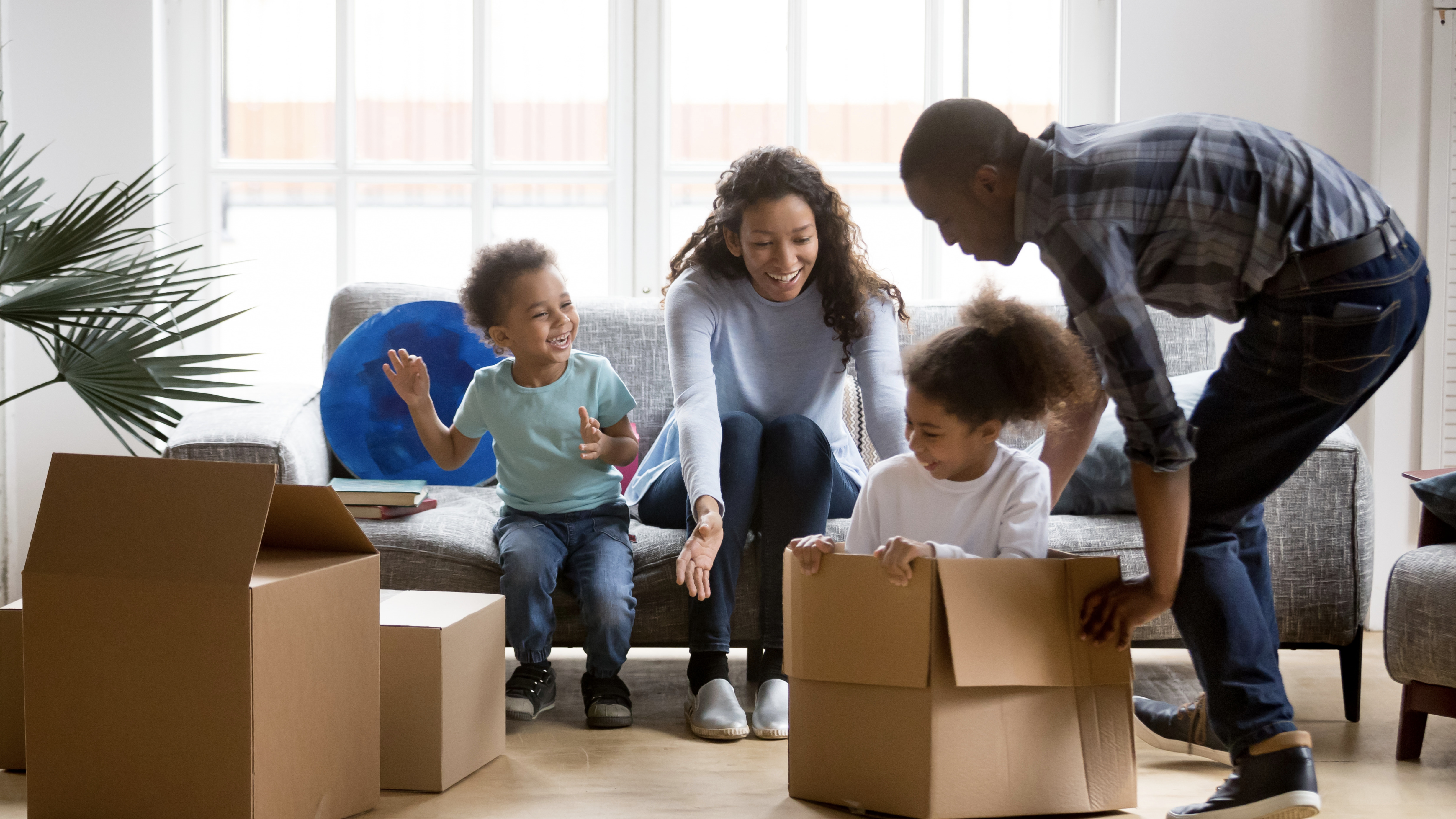 Happy playful African American family moving in new apartment