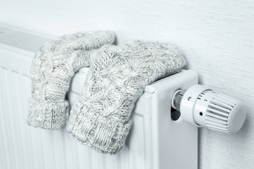 Heating radiator with knitted mittens indoors