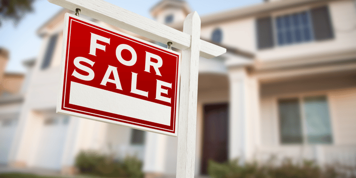Home with for sale sign in yard