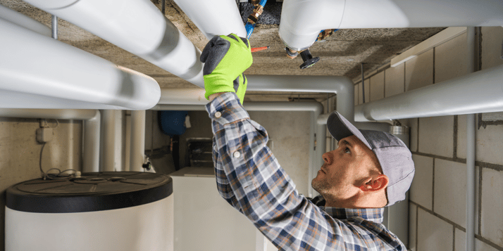 Plumber working on plumbing pipes